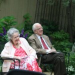 Mary Pat (left) and Mike True (right) at the 2015 Kunitz Medal ceremony. Two figure seated in a garden setting. Mary Pat True (left) and Mike True (right)